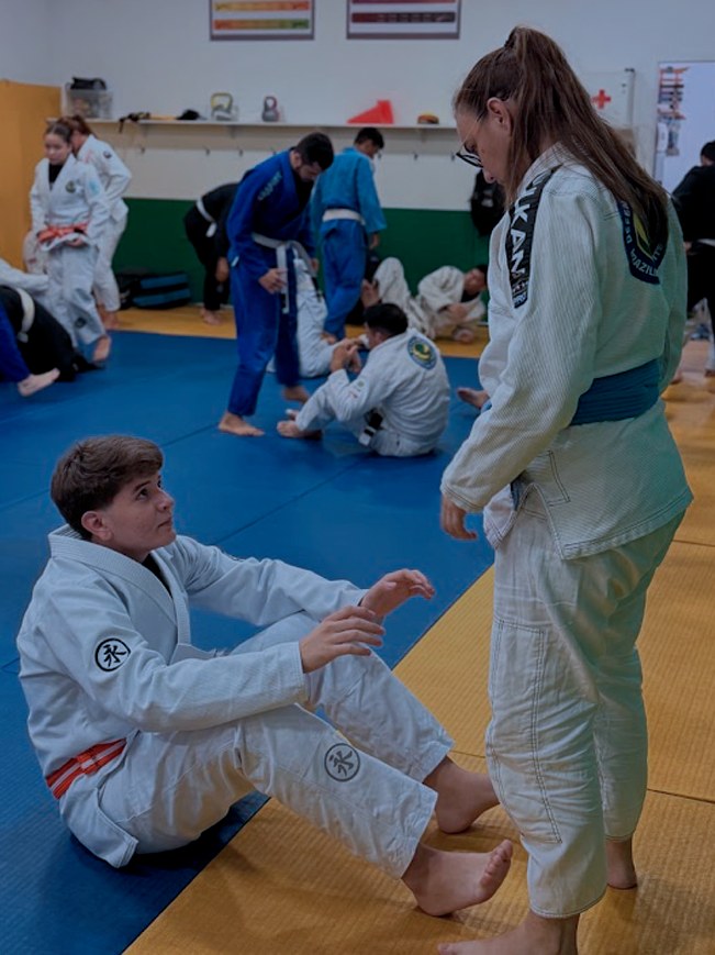 Adultos treinando Jiu-Jitsu no tatame da Defensores da Arte